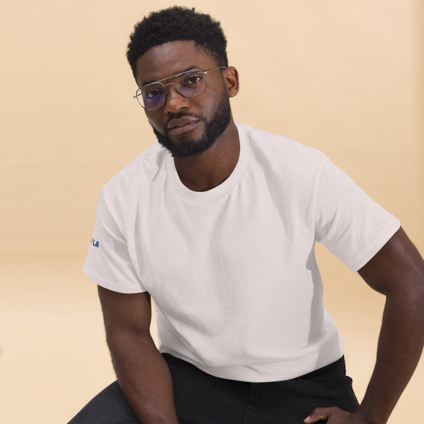 Man wearing a white t-shirt with a logo on a beige background