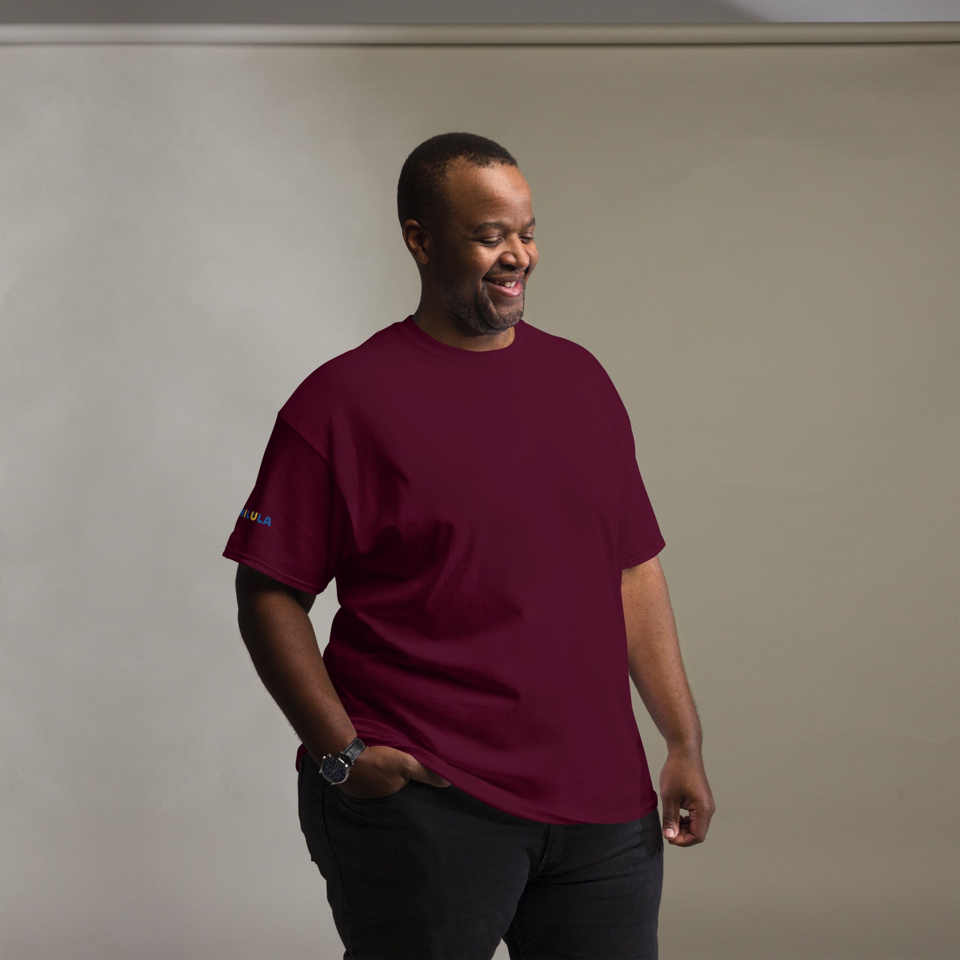Man wearing a maroon t-shirt against a plain background