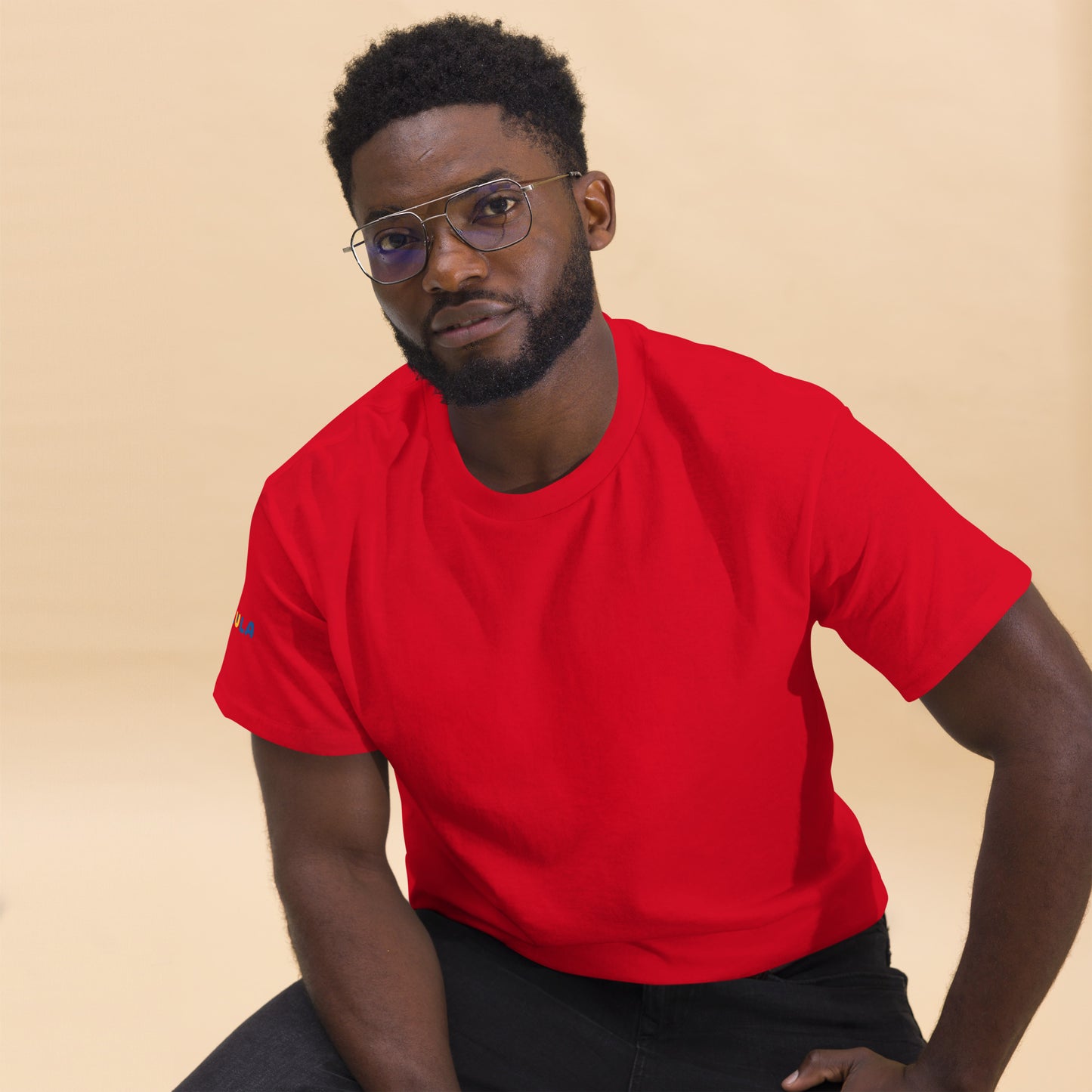 Man wearing a red t-shirt against a beige background