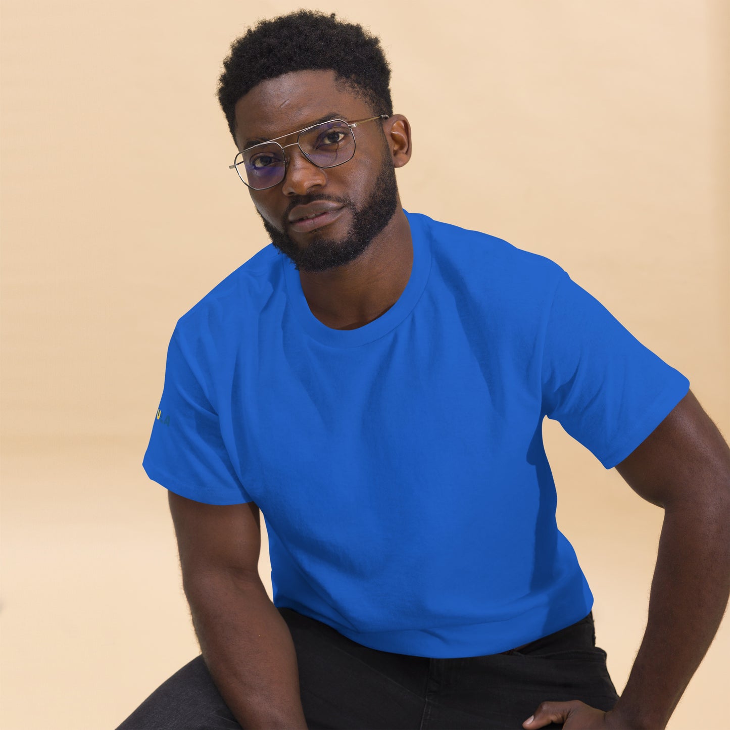 Man wearing a blue t-shirt against a beige background