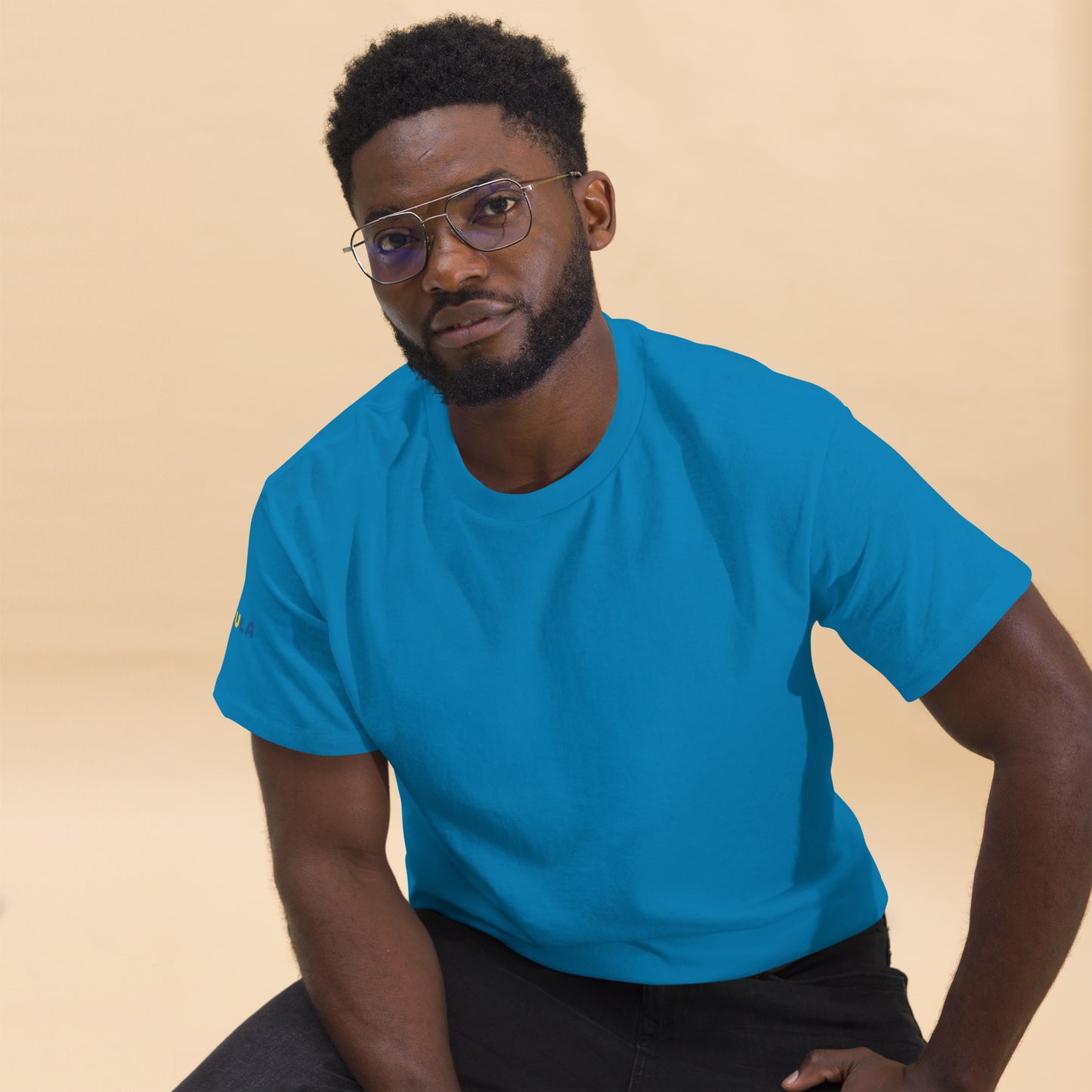 Man wearing a blue t-shirt against a beige background