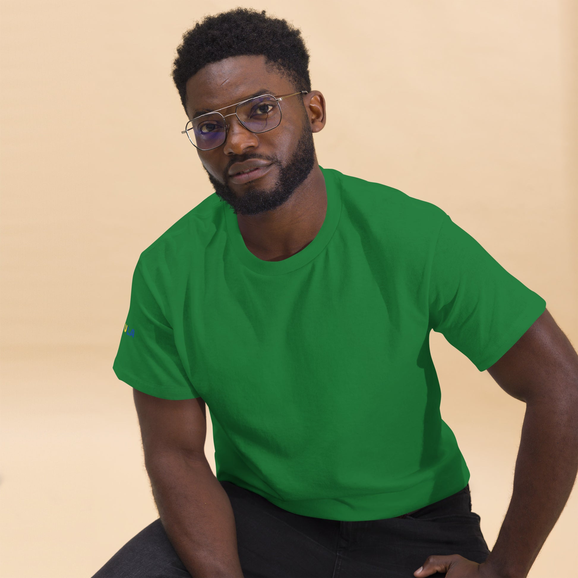 Man wearing a green t-shirt against a beige background