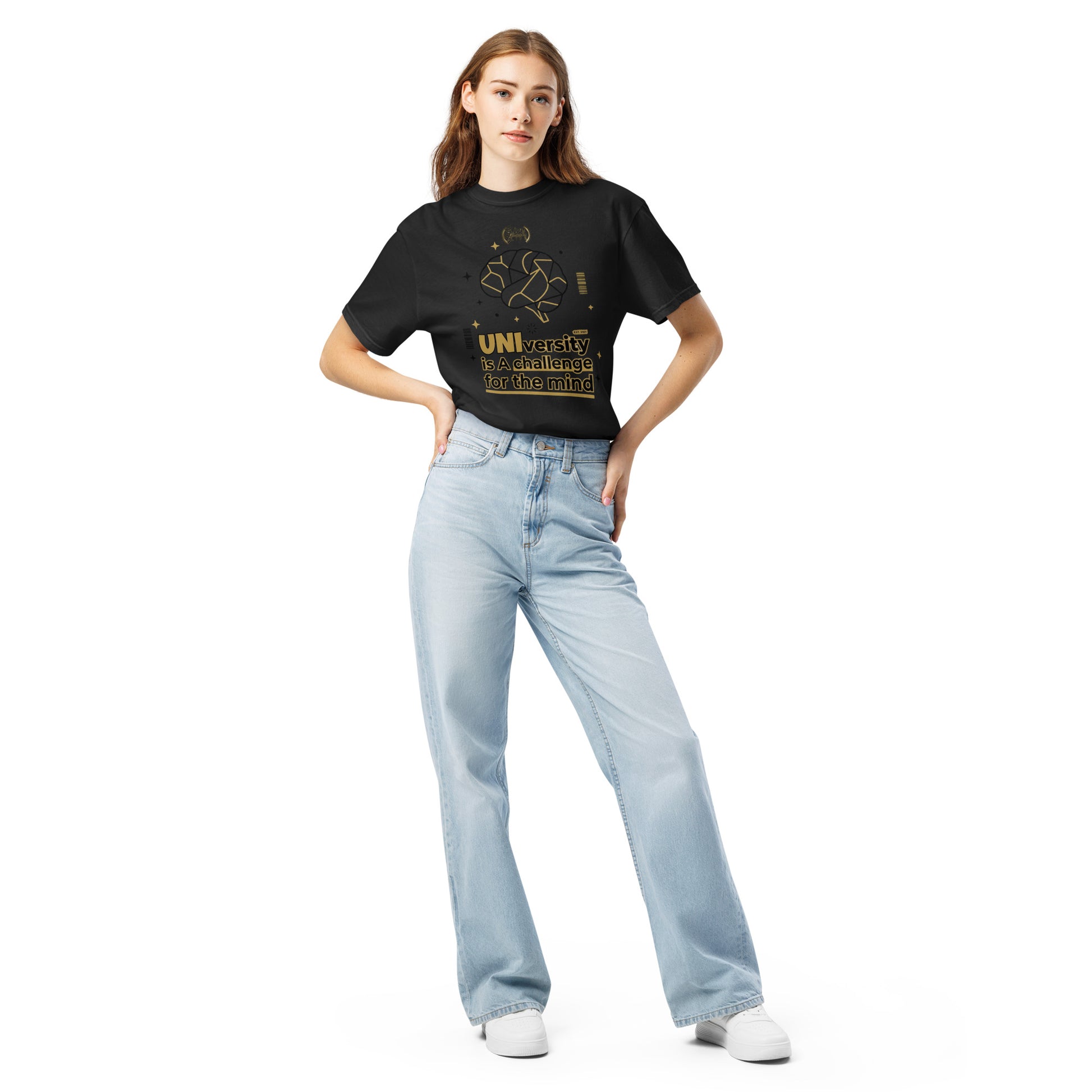 Woman wearing a dark gray t-shirt with a small graphic and light blue jeans on a white background