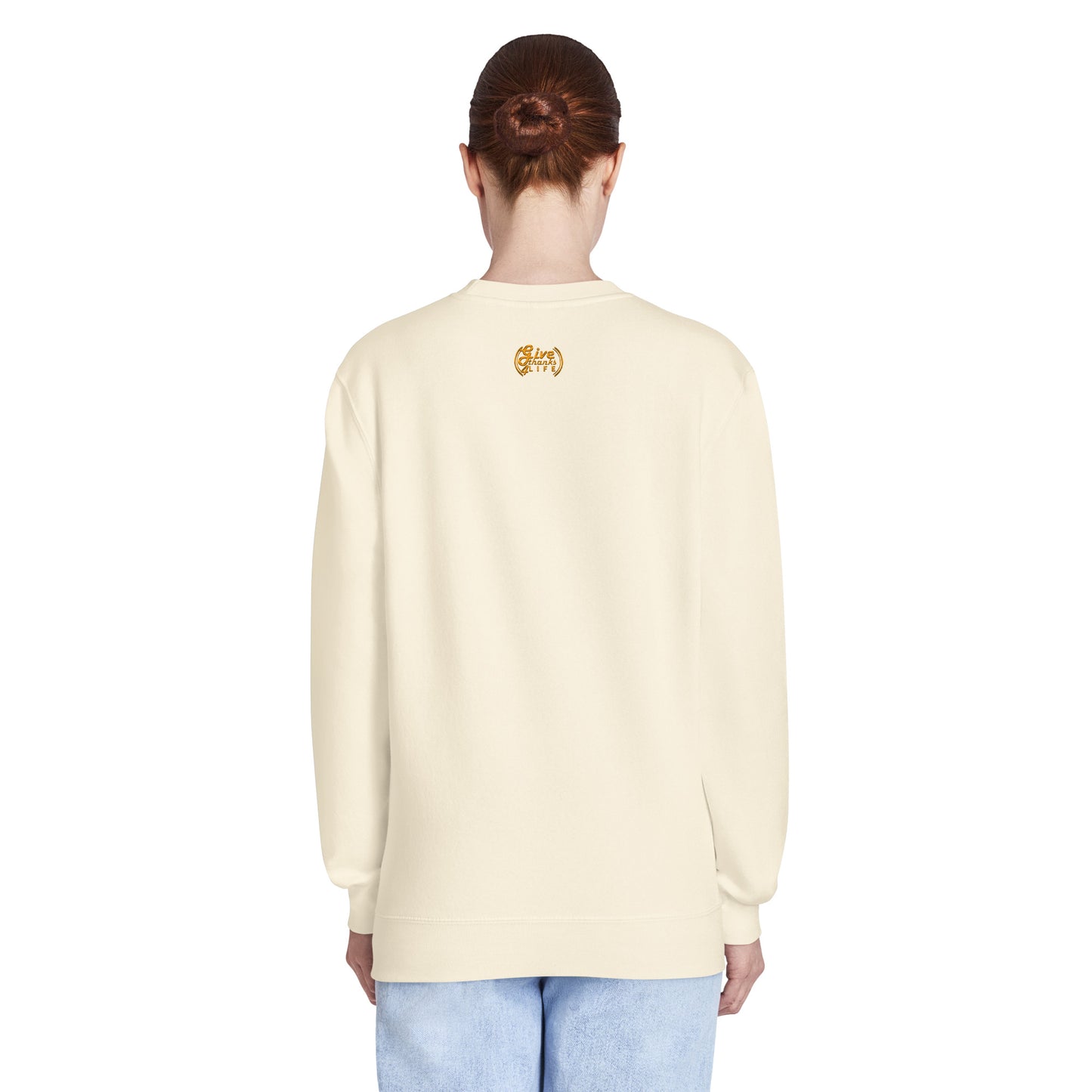 Person wearing a light-colored sweater and light blue jeans on a white background