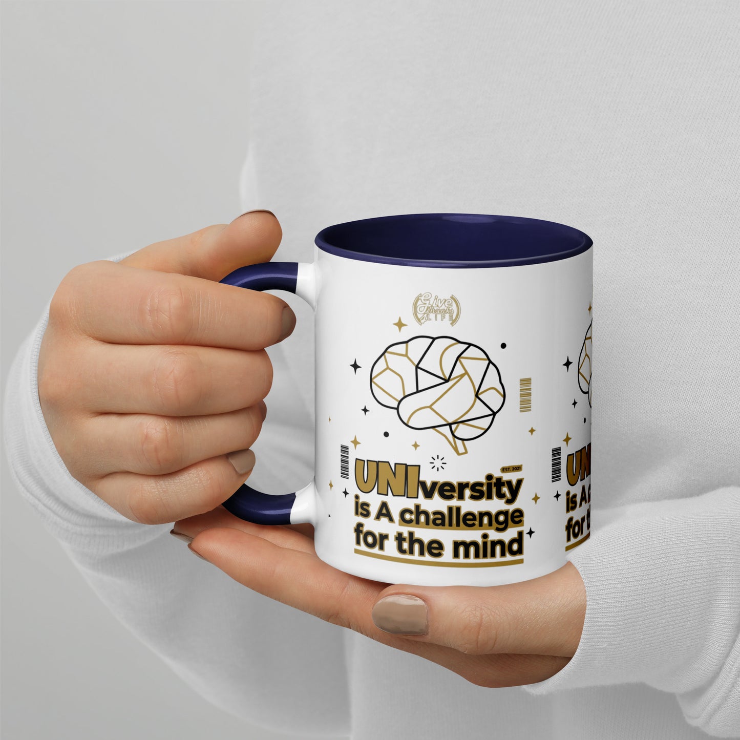 Person holding a mug with 'UNIversity is A challenge for the mind' design.