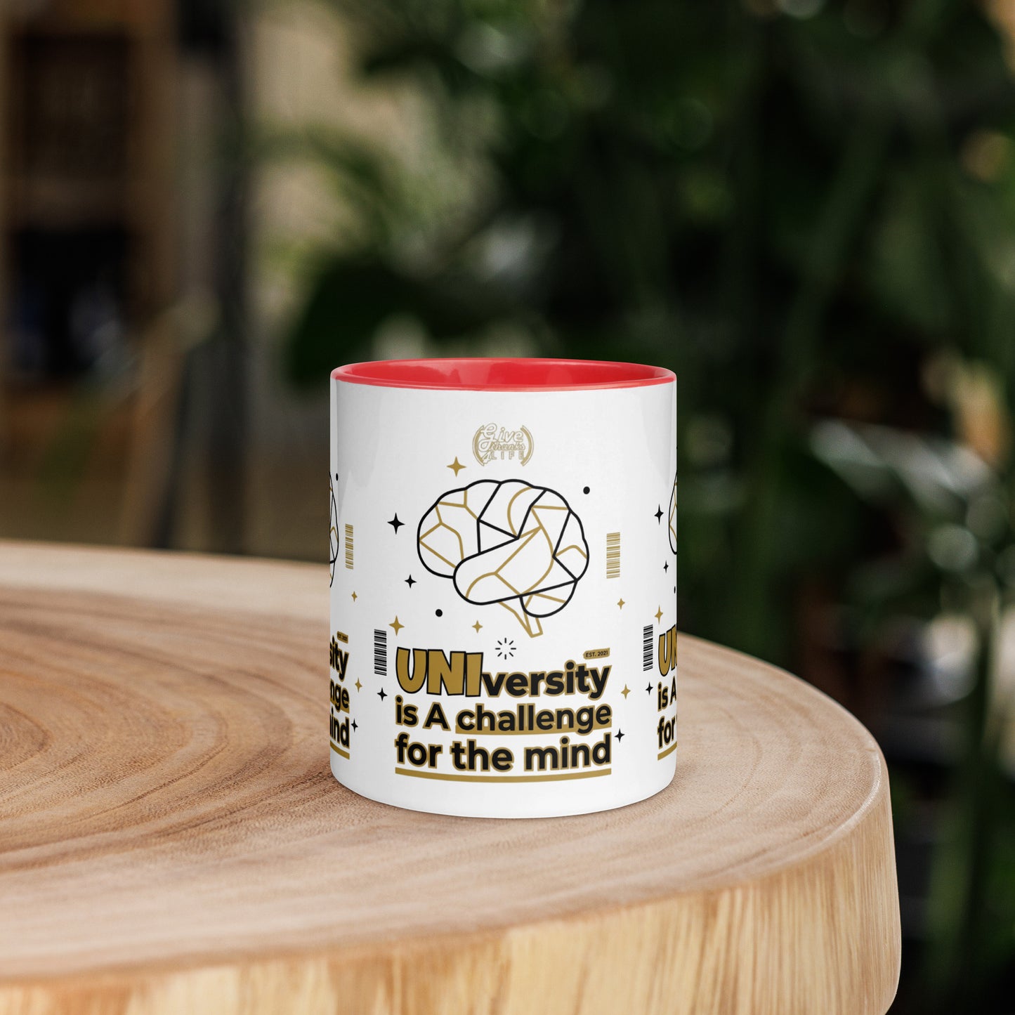 White mug with red interior on a wooden surface, featuring text and graphics.