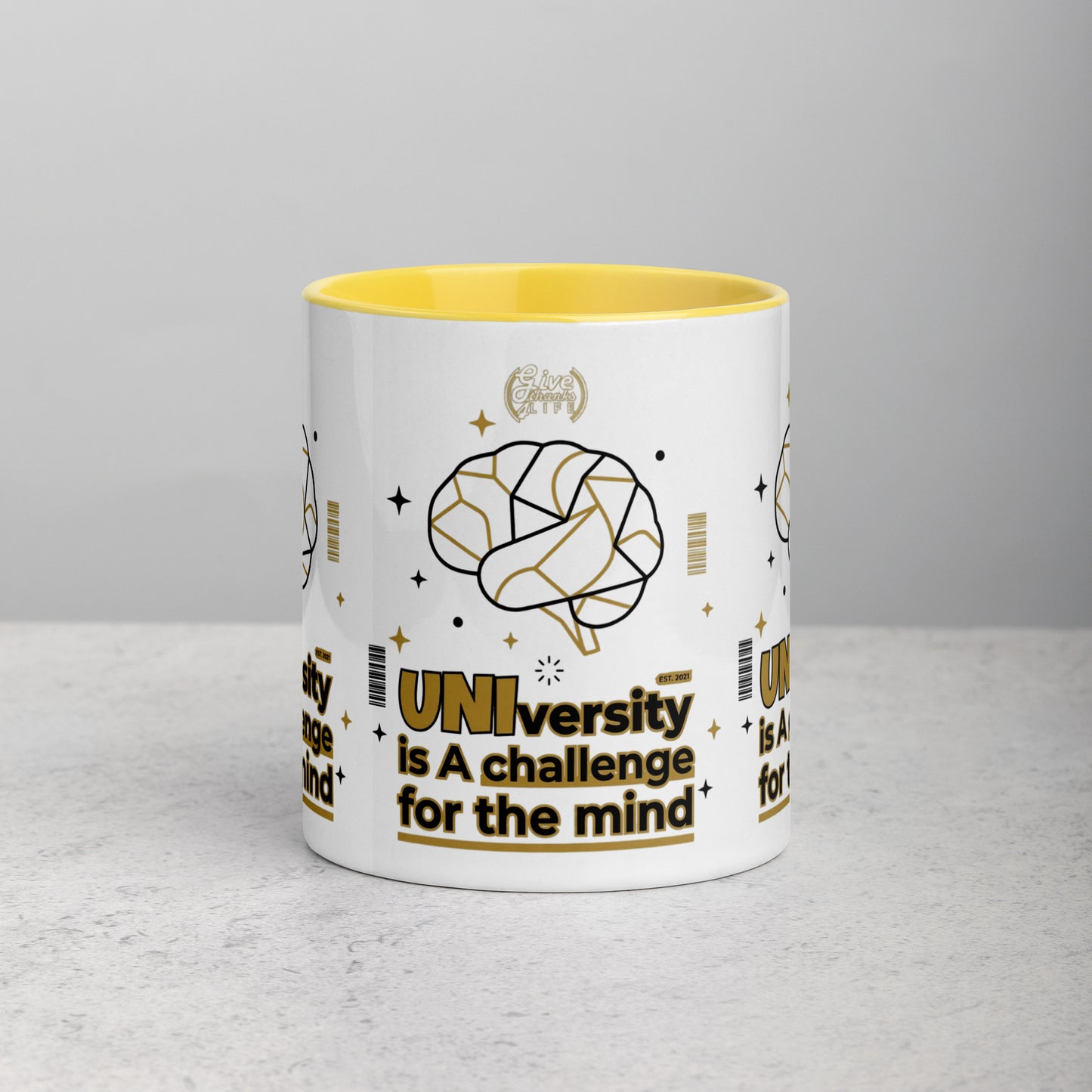 White mug with yellow interior and brain graphic on a gray surface