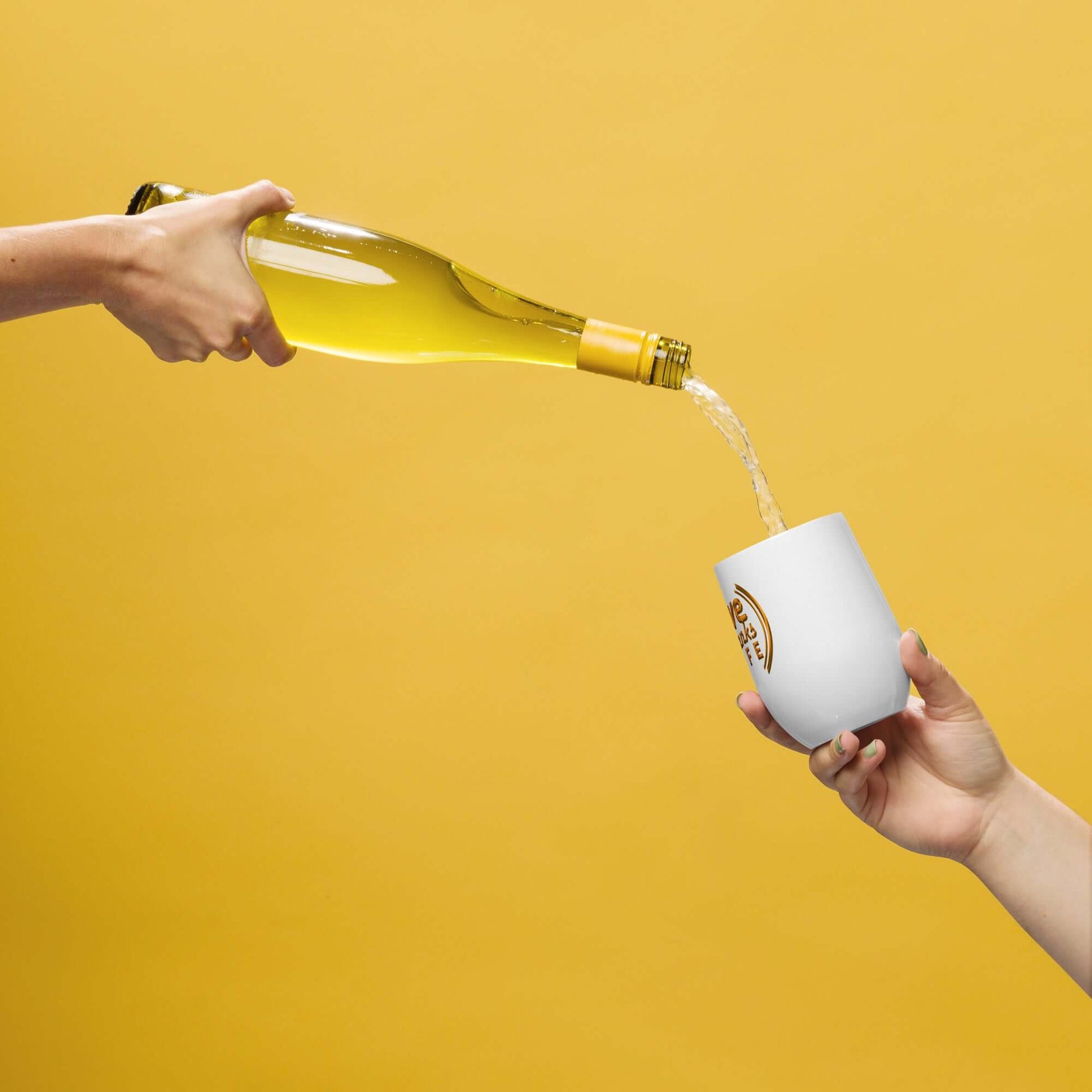 Person pouring a yellow liquid from a bottle into a white cup with a logo on a yellow background