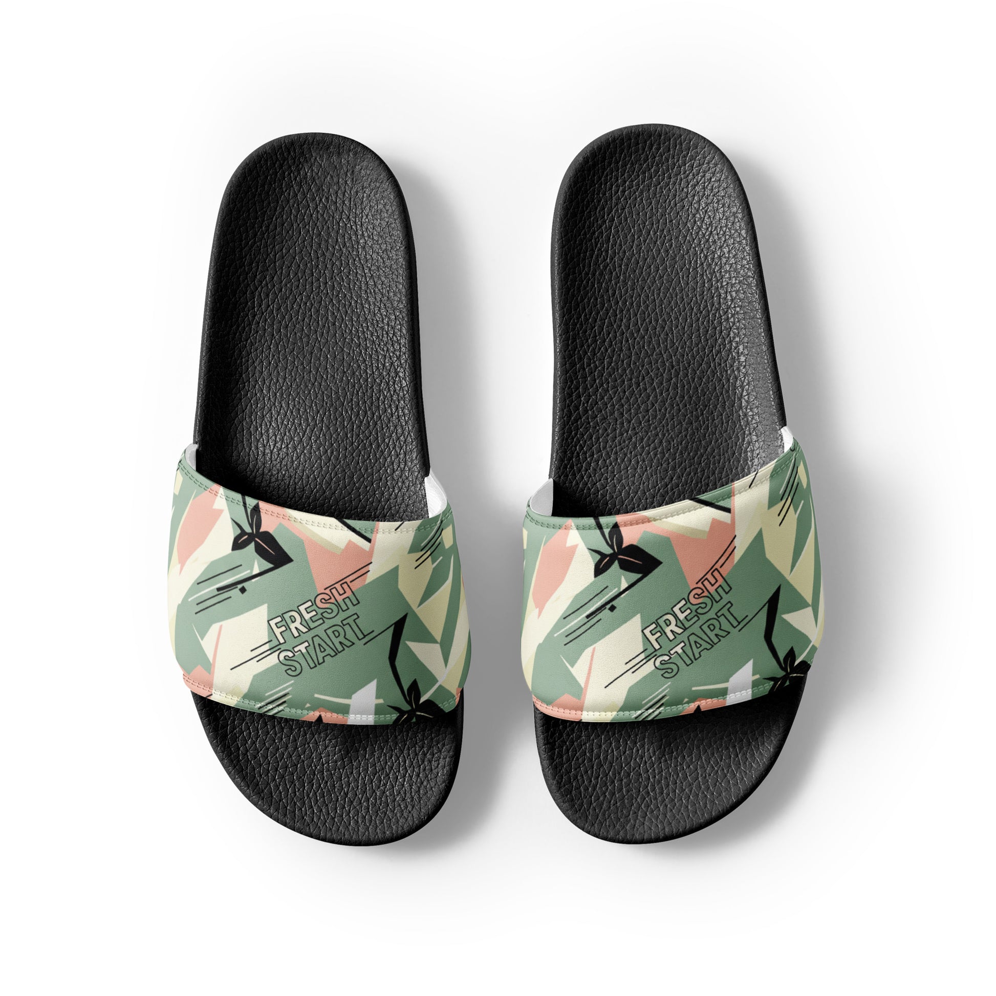 Black slide sandals with tropical patterned straps on a white background