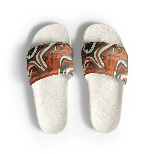 Pair of white slides with patterned straps on a white background