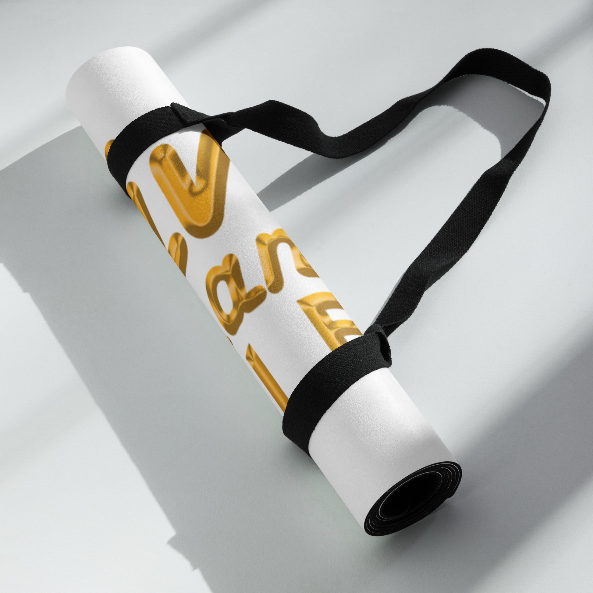 White yoga mat with black strap on a light gray background