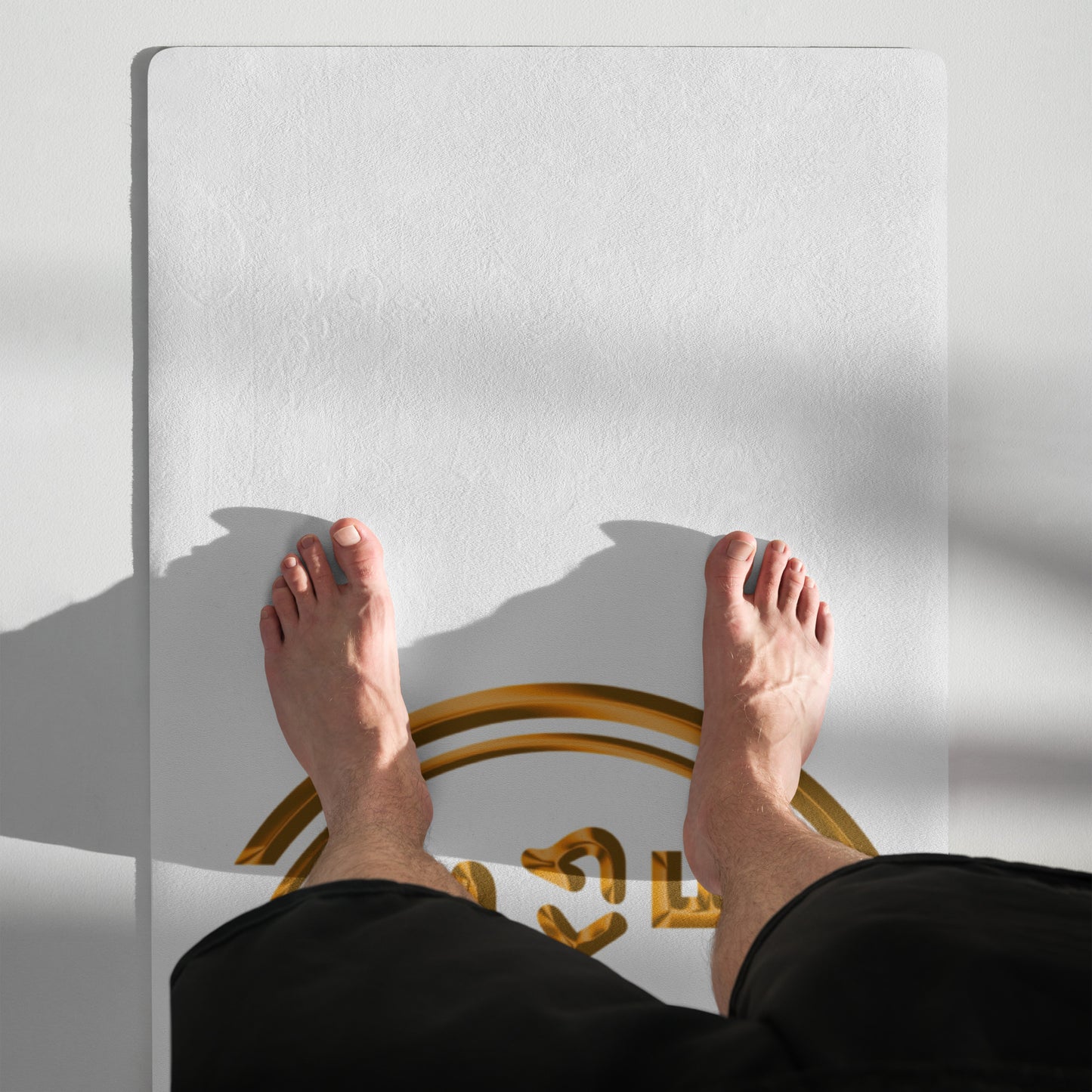 Person standing on a white platform with a gold circular object underneath, casting a shadow.