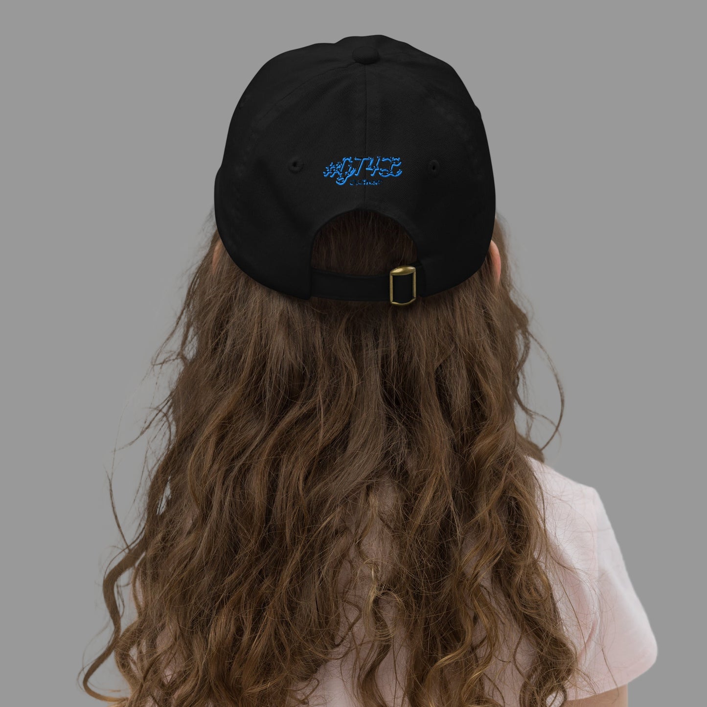 Person wearing a black cap with a blue logo on a plain background