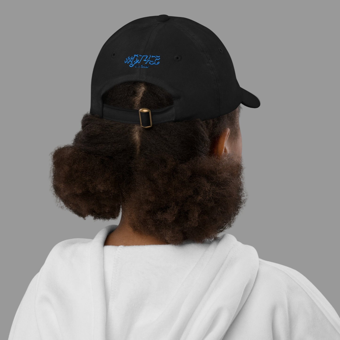 Person wearing a black cap with a logo on the back, white hoodie, on a white background