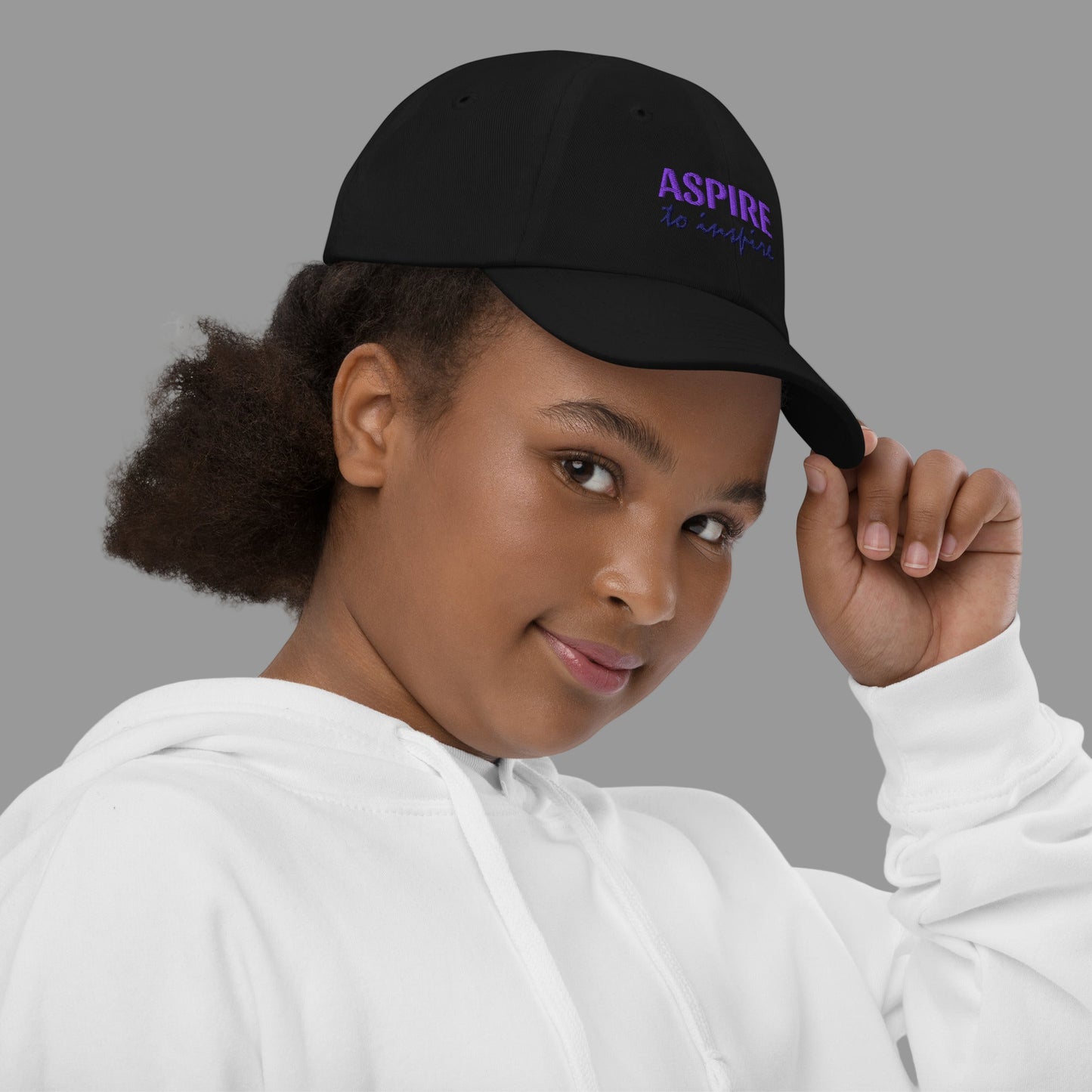 Person wearing a black cap with 'ASPIRE' text on a white background