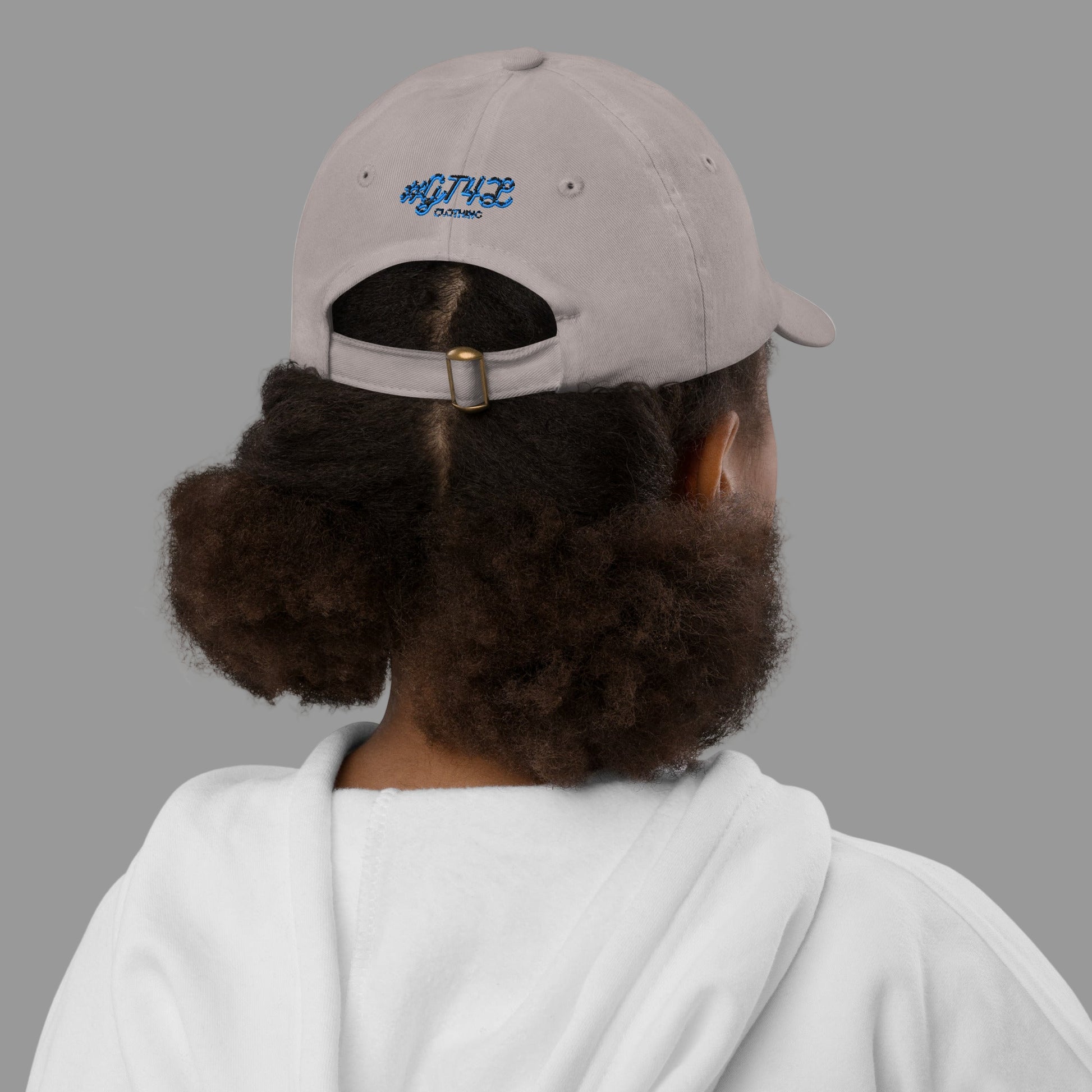 Person wearing a beige cap with a logo on the back, facing away from the camera.