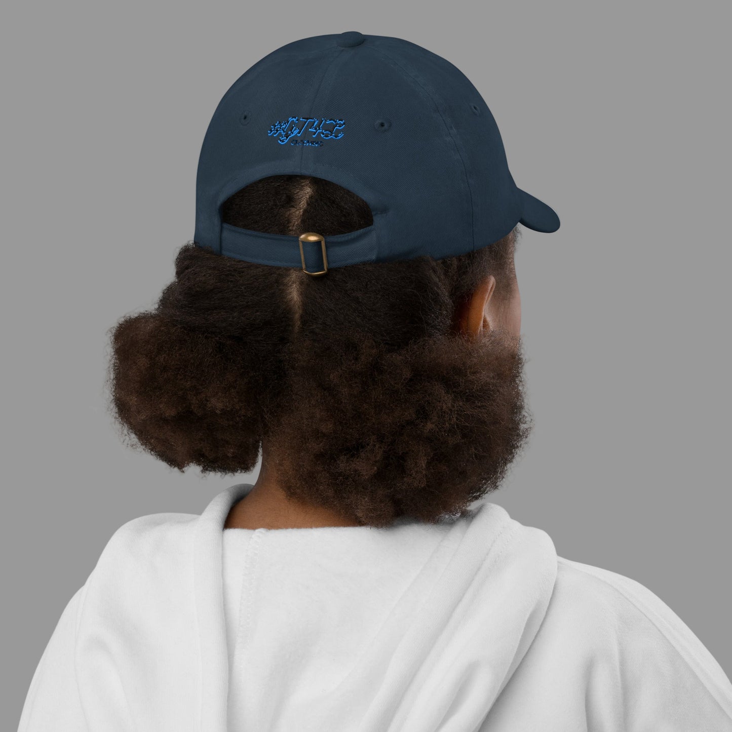 Person wearing a navy blue cap with a logo on the back, facing away from the camera.