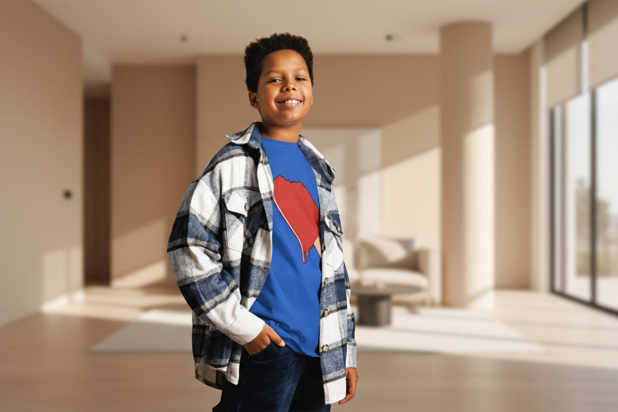 Child wearing a blue shirt with a red heart design and a plaid jacket against a striped background