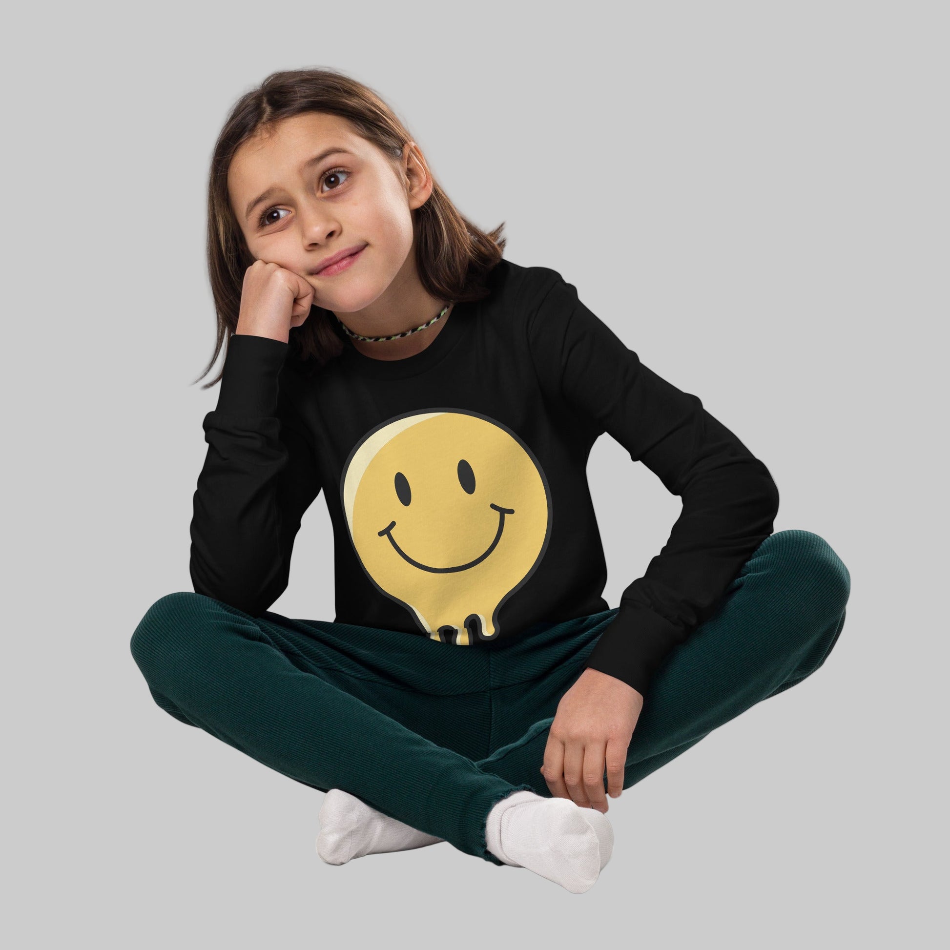 Child wearing a black hoodie with a yellow smiley face design on a white background