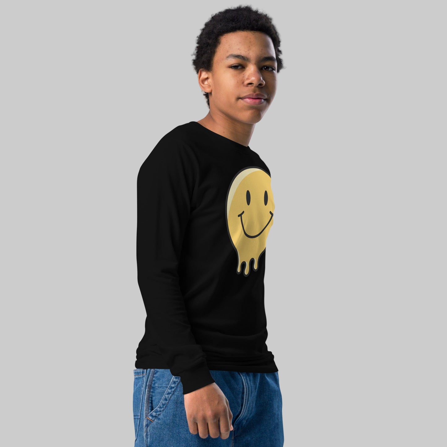 Person wearing a black sweatshirt with a smiley face design on a white background