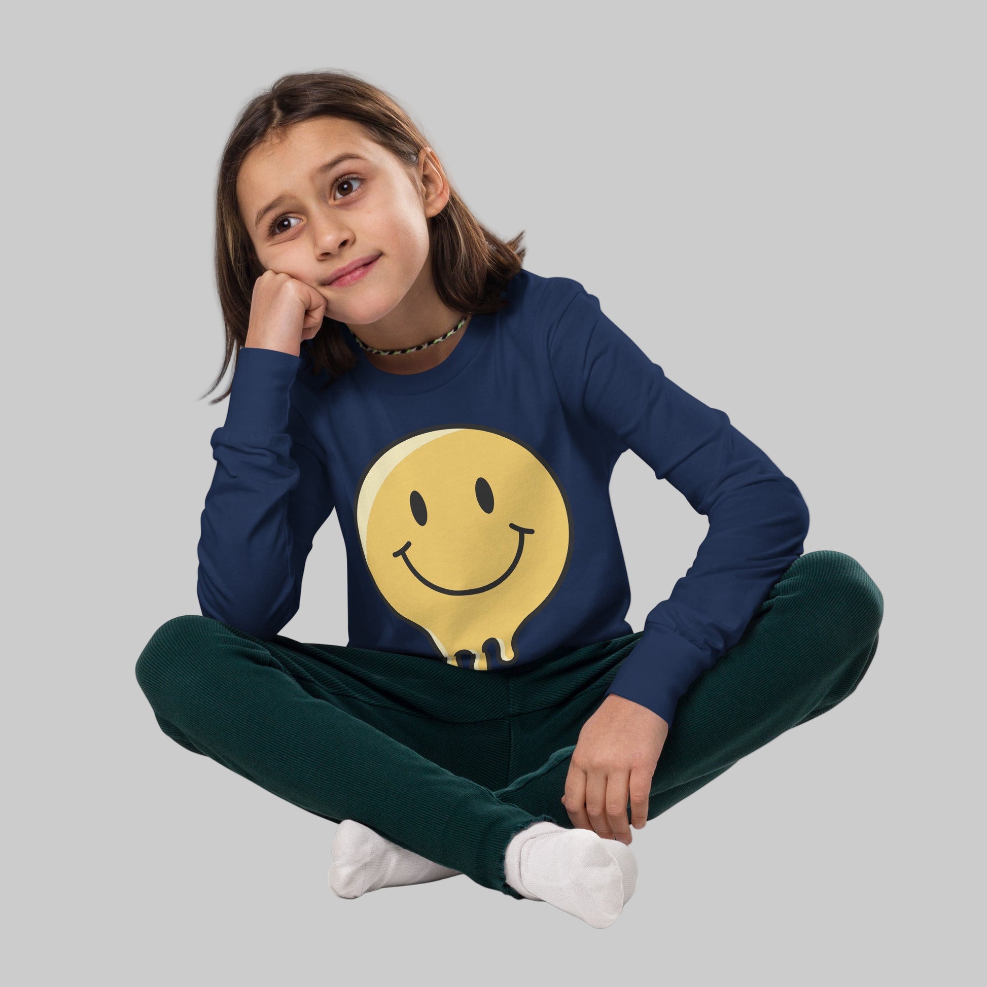 Child wearing a navy blue sweatshirt with a yellow smiley face design on a white background