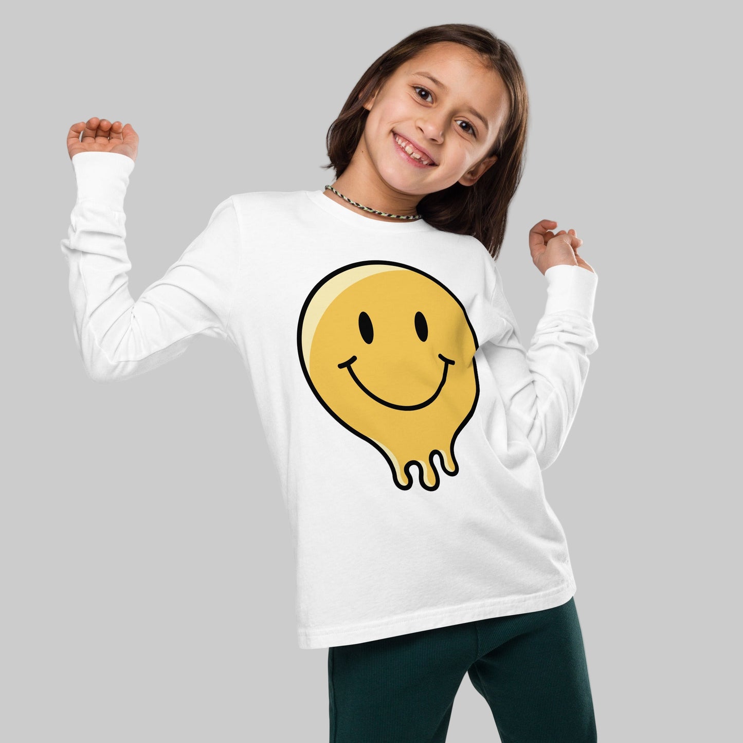 Child wearing a white long-sleeve shirt with a yellow smiley face design on a white background