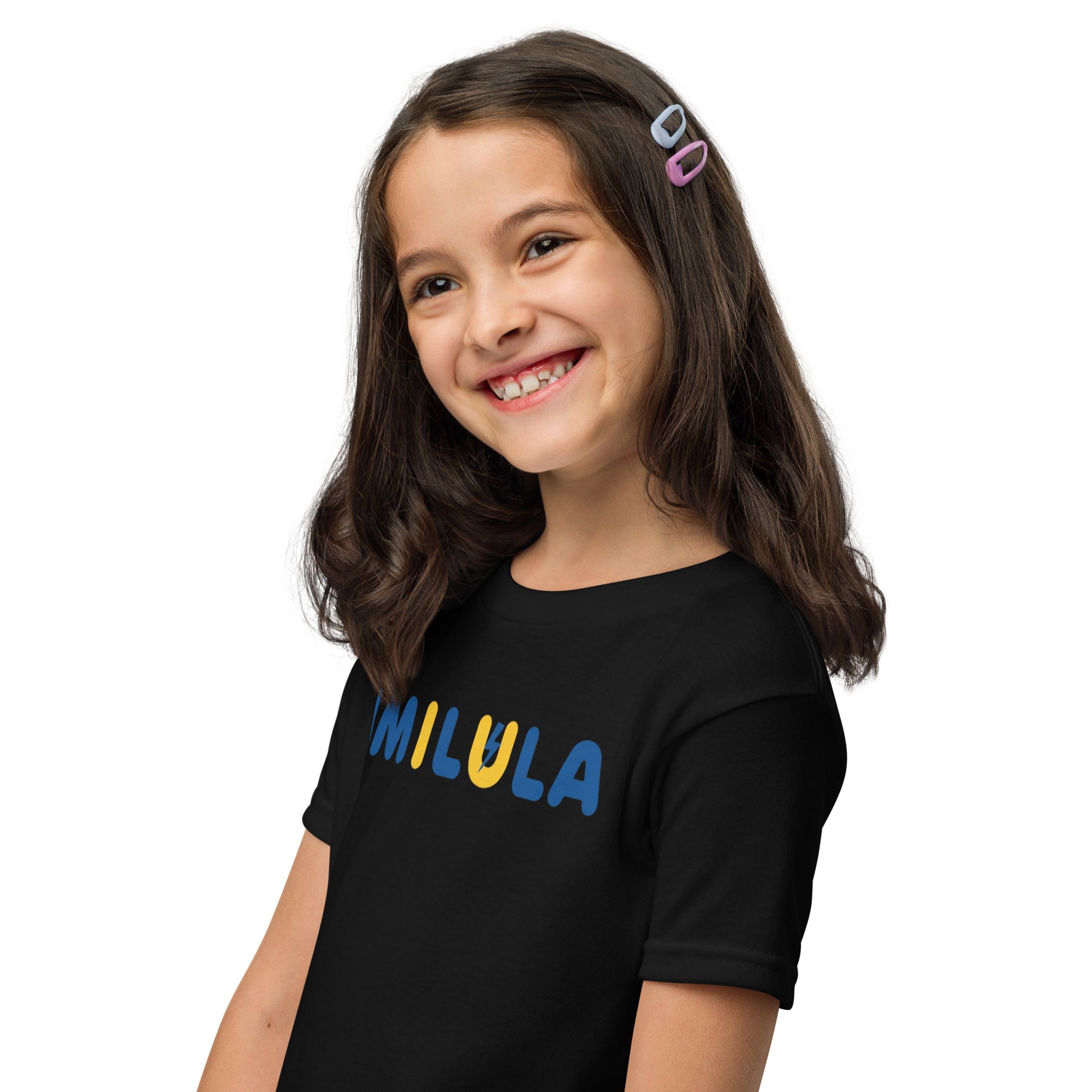 Young girl wearing a black t-shirt with 'WILULA' printed on it against a white background