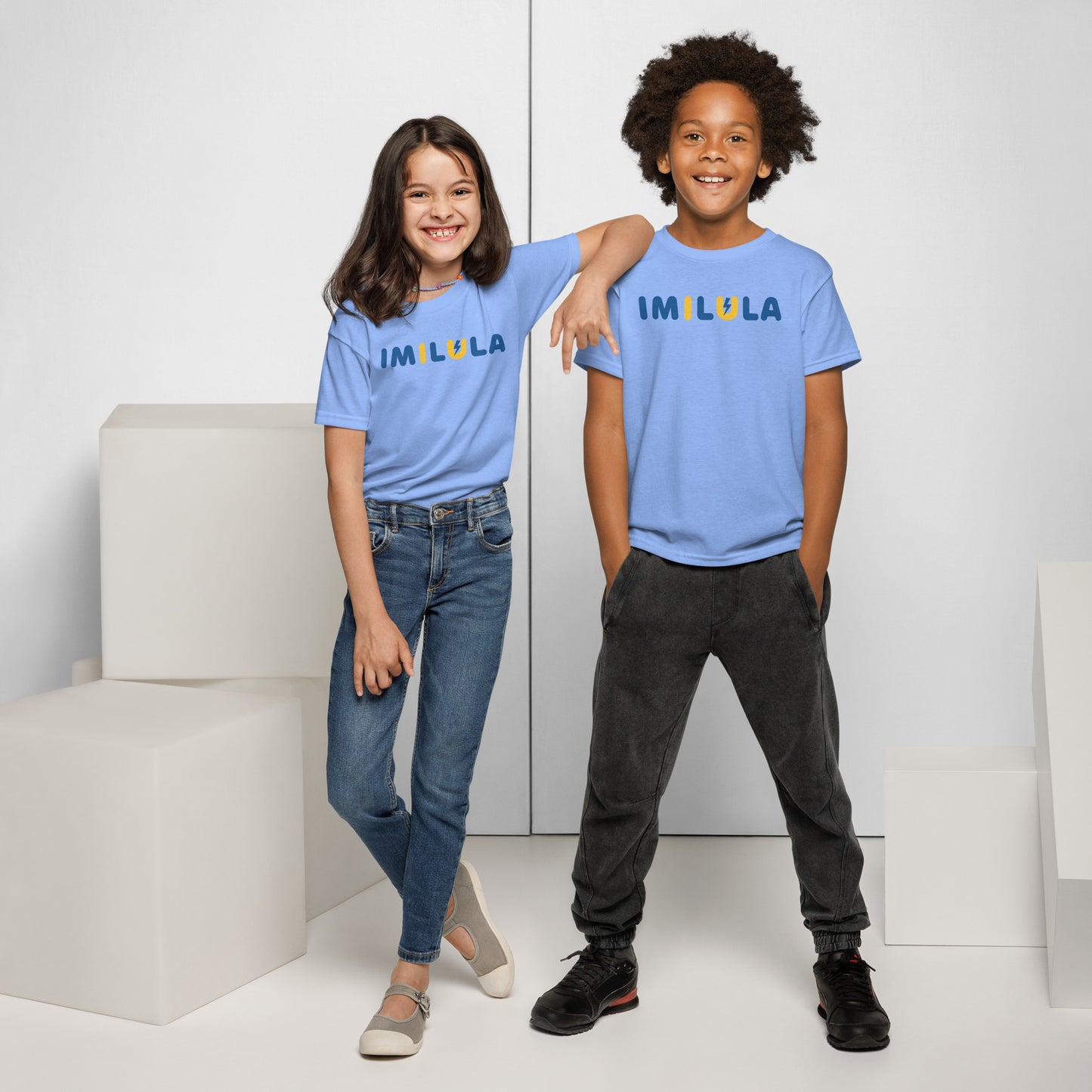 Two children wearing blue t-shirts with text, standing against a white background.