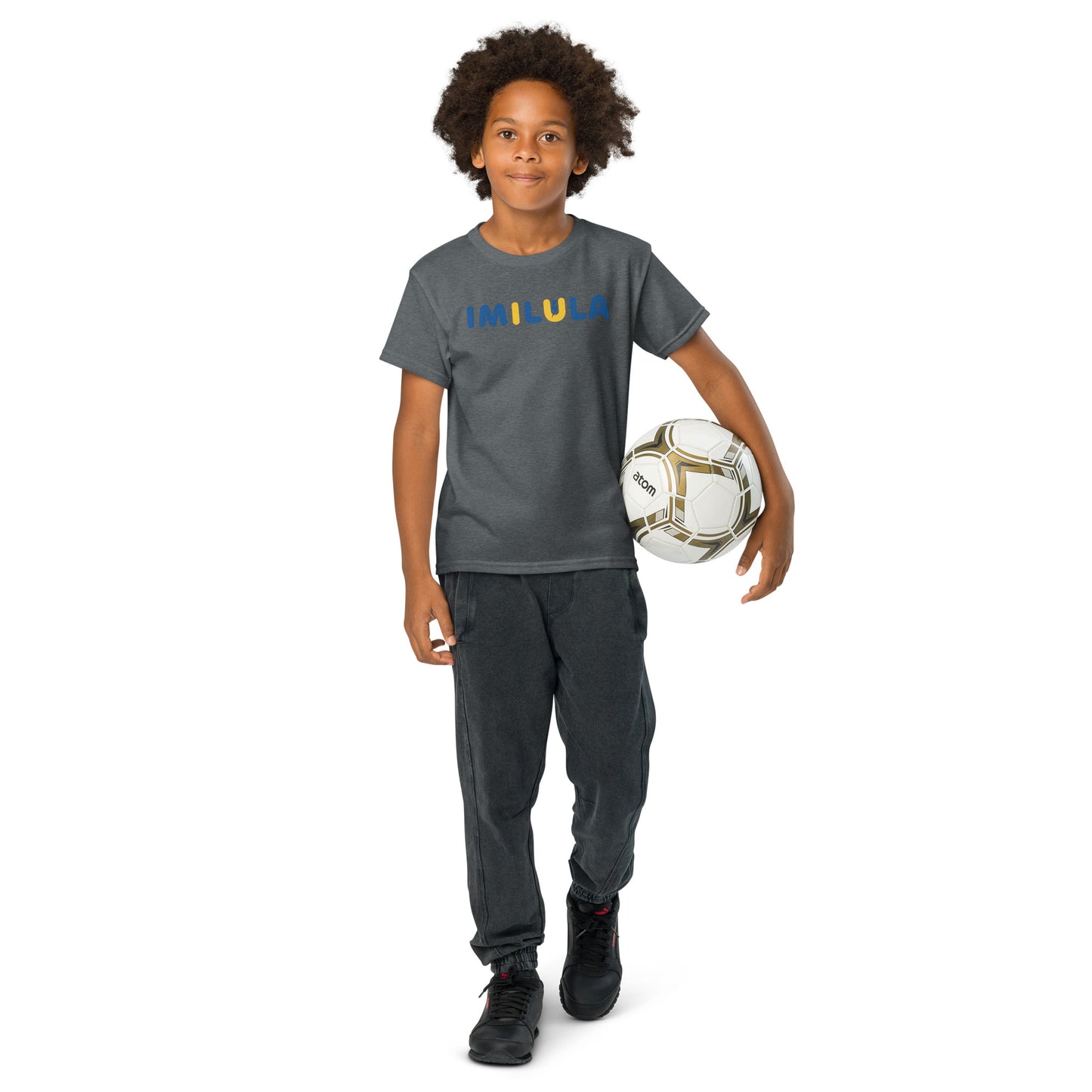 Child wearing a gray 'Faith Family Football' t-shirt and holding a soccer ball on a white background