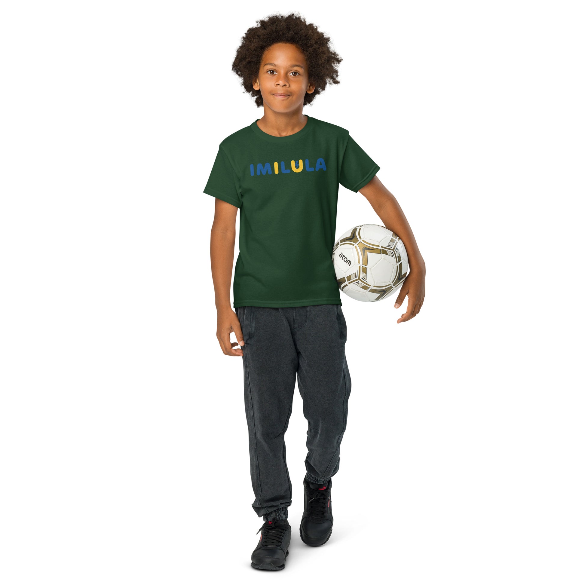 Child holding a soccer ball wearing a green t-shirt with 'IMILULA' text on a white background