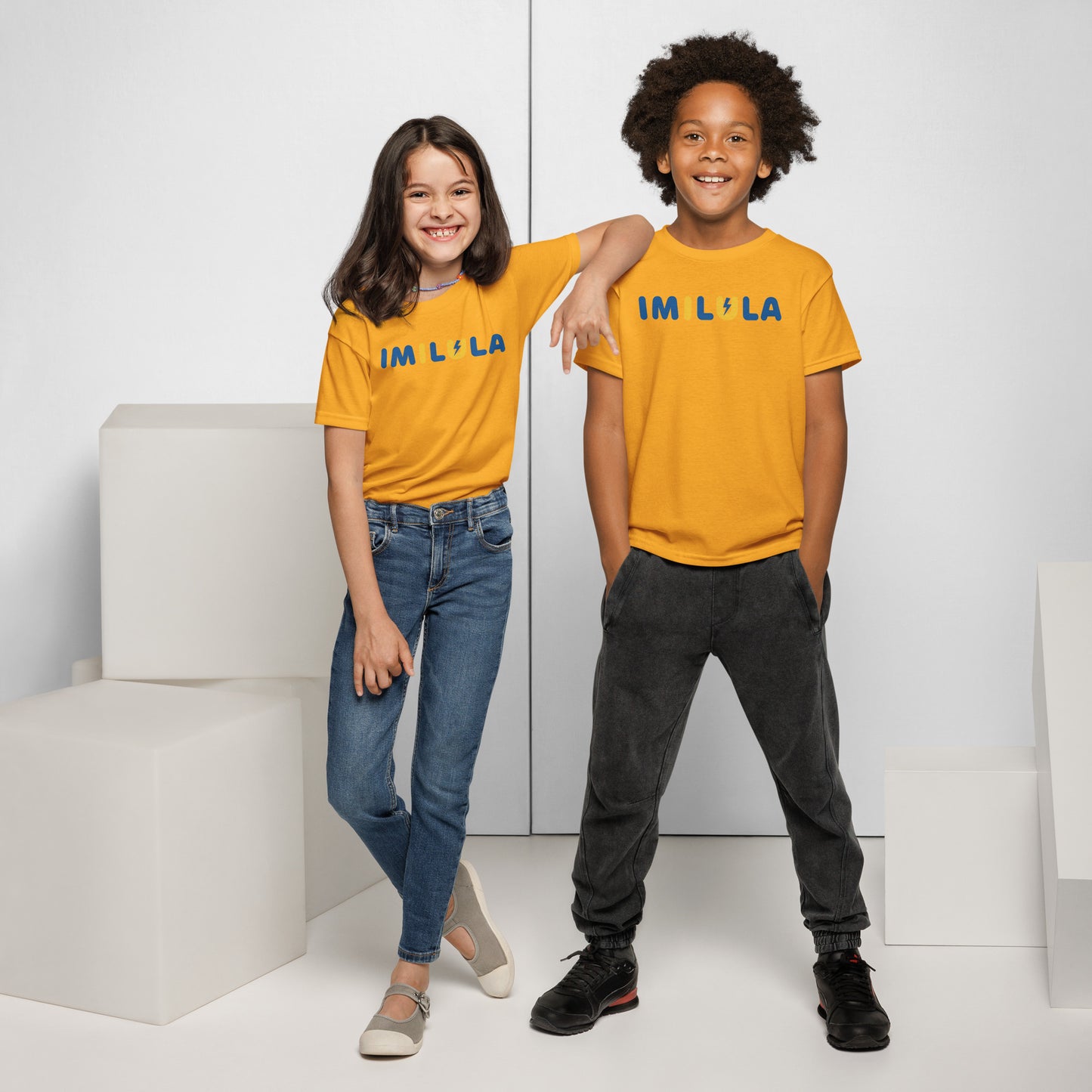 Two children wearing matching yellow t-shirts with a dragon design on a white background.