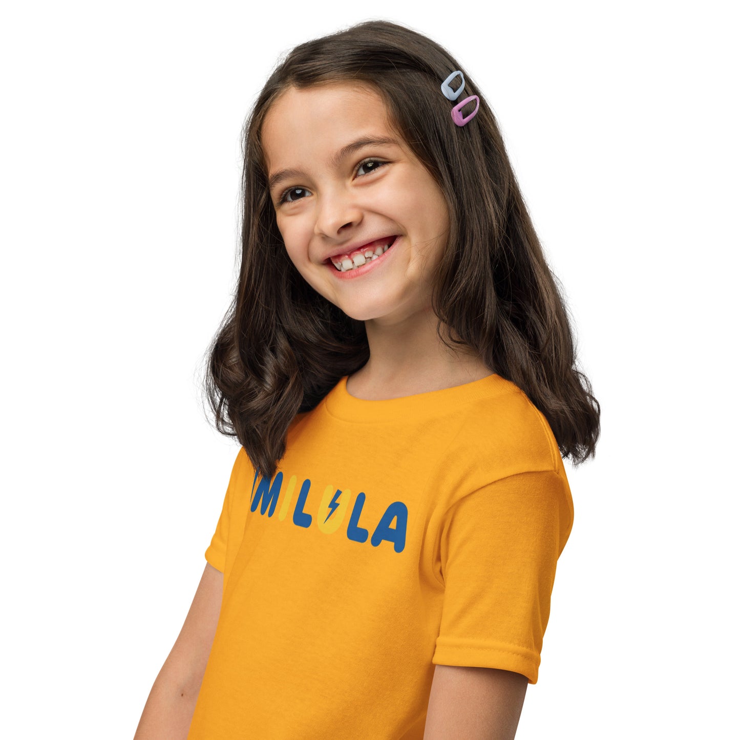Young girl wearing an orange t-shirt with 'MILA' printed on it against a white background