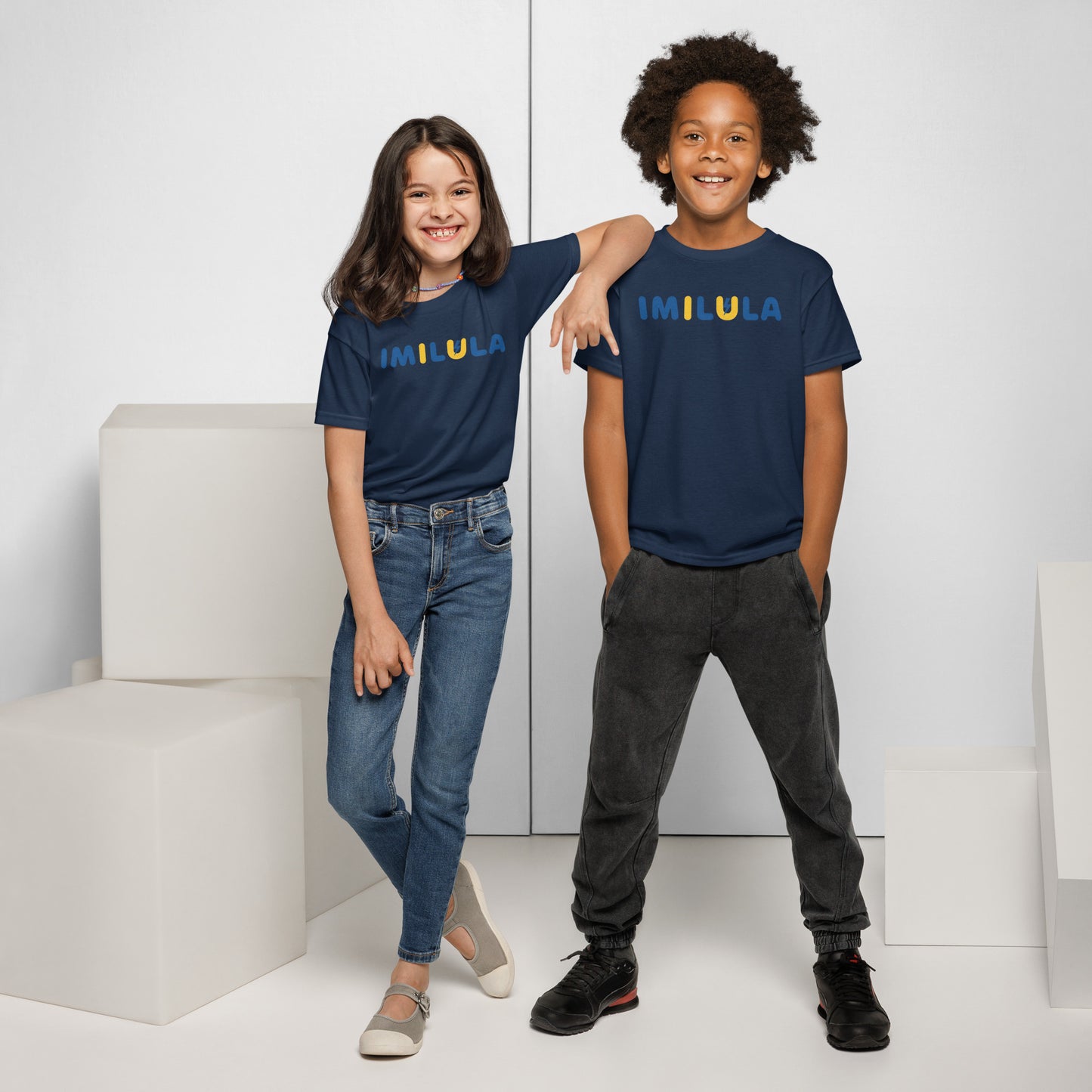 Two children wearing matching navy blue t-shirts with a logo on a white background