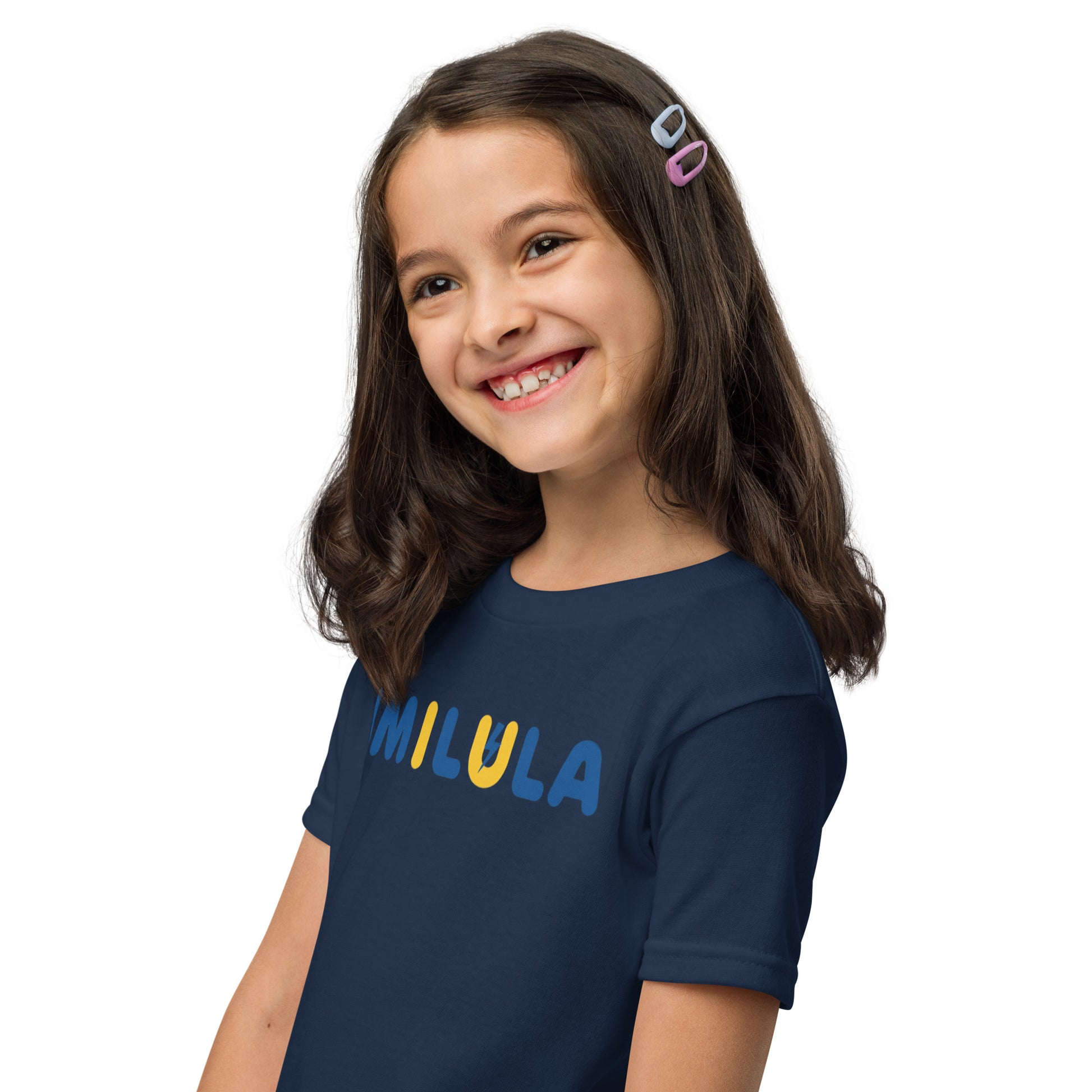 Young girl wearing a navy blue t-shirt with 'MIKULA' printed on it against a white background