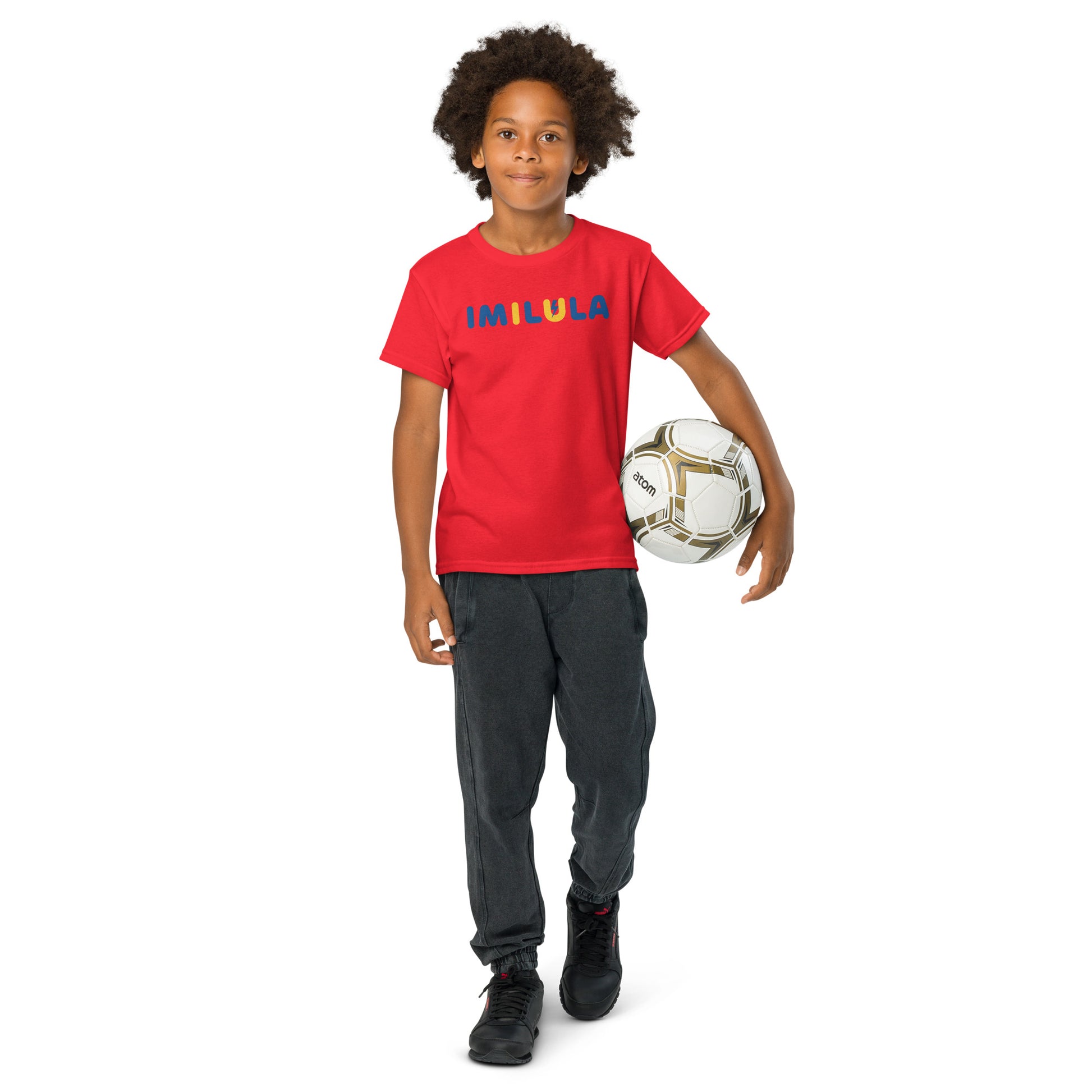 Child wearing a red shirt with colorful text, holding a soccer ball on a white background